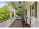 Long covered porch with ceiling fans, rocking chairs, and swing with cushions at 407 Pitt St, Mount Pleasant, SC 29464