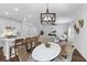 Bright dining area with seating, an open kitchen and living area, modern chandelier and hardwood floors at 481 Woodland Shores Rd, Charleston, SC 29412