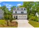 Charming two-story home with black roof, white siding, two car garage, and a well manicured front yard at 481 Woodland Shores Rd, Charleston, SC 29412