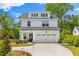 Charming two-story modern farmhouse exterior with black roof, white siding, and a well manicured front yard at 481 Woodland Shores Rd, Charleston, SC 29412