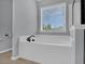 Clean and modern bathroom featuring a deep soaking tub and a large window for natural light at 482 Sanders Farm Ln, Wando, SC 29492