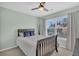 Light-filled bedroom features a cozy bed, a ceiling fan, and a large window with peaceful views at 482 Sanders Farm Ln, Wando, SC 29492