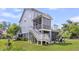 Exterior view of a three-story home showcasing a screened-in porch, deck, and backyard at 482 Sanders Farm Ln, Wando, SC 29492