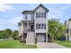 Inviting exterior of a three-story home with a front porch, garage, and well-maintained landscaping at 482 Sanders Farm Ln, Wando, SC 29492
