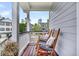 Relaxing porch featuring rocking chairs with cushions and decorative pillows overlooking neighborhood at 482 Sanders Farm Ln, Wando, SC 29492