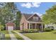 Charming red two-story home with a manicured lawn, complemented by a detached garage and inviting curb appeal at 4856 Cane Pole Ln, Summerville, SC 29485