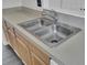 Close-up of a stainless steel, double basin sink with modern faucet and wood cabinetry at 4856 Cane Pole Ln, Summerville, SC 29485