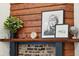 A fireplace with a wooden mantelpiece is styled with pictures, a plant and decorative features at 5 Addison St, Charleston, SC 29403