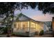 Charming one-story home featuring a cozy porch with railings, landscaped yard, and a welcoming front entrance at 5 Addison St, Charleston, SC 29403