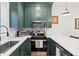 Modern kitchen featuring white countertops and stainless steel appliances with green cabinets above at 5 Addison St, Charleston, SC 29403