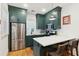 Well-equipped kitchen with green cabinets, stainless steel appliances, and ample counter space for cooking at 5 Addison St, Charleston, SC 29403