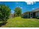 Large backyard featuring a well-maintained lawn, mature trees, and a screened-in porch for relaxation at 5008 Bowles Dr, Summerville, SC 29485