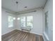 Cozy dining area featuring wood floors, natural light from three windows, and a modern chandelier at 5008 Bowles Dr, Summerville, SC 29485