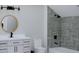 Modern bathroom with a round mirror, vanity with storage, and stylish tiled shower at 5213 Seewee Rd, Awendaw, SC 29429