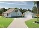 Charming home with a light blue facade, complemented by a matching detached garage and spacious driveway at 5213 Seewee Rd, Awendaw, SC 29429