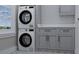 Efficient laundry room with stacked washer and dryer, plus ample storage cabinets for organization at 5213 Seewee Rd, Awendaw, SC 29429