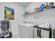 Convenient laundry room with washer, dryer, shelving, and Van Gogh art print at 523 Fern Tree Dr, Summerville, SC 29486