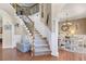 Elegant staircase with wooden banister, decorative ironwork, and an arched entry to the dining room at 5401 Diston Court, North Charleston, SC 29420