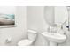 Clean powder room with a pedestal sink, toilet, round mirror and beach-themed artwork at 549 Richfield Way Way, Summerville, SC 29486