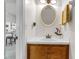 Charming powder room featuring a wood cabinet, updated vanity and a decorative mirror at 565 Travelers Blvd, Summerville, SC 29485