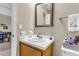 Cozy bathroom features a vanity sink with a wooden cabinet base and a neutrally framed mirror at 565 Travelers Blvd, Summerville, SC 29485
