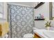 Well-lit bathroom features patterned shower curtain, modern vanity, and open shelving with bath supplies at 565 Travelers Blvd, Summerville, SC 29485