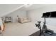 Open bonus room features neutral carpeting, a comfortable sofa, and a stationary bicycle for workouts at 667 Shortwood St, Charleston, SC 29412