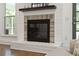 Close up of a modern fireplace with brick surround and a dark wood mantel at 667 Shortwood St, Charleston, SC 29412