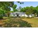 Beautiful white home with a black roof, surrounded by mature trees and green lawn at 667 Shortwood St, Charleston, SC 29412