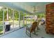 Relaxing screened porch with ceiling fan and rocking chairs offers views of the fenced backyard at 667 Shortwood St, Charleston, SC 29412