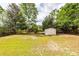 Large backyard with lush grass and mature trees, plus shed for extra storage or hobbies at 7655 Ovaldale Dr, North Charleston, SC 29418
