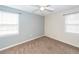 Carpeted bedroom with neutral colors, two windows, and ceiling fan for comfort at 7655 Ovaldale Dr, North Charleston, SC 29418