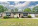 Inviting single-story brick home with a manicured lawn, updated paint and shutters, and attached garage at 7655 Ovaldale Dr, North Charleston, SC 29418