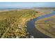 Breathtaking aerial view of homes along a tranquil river surrounded by lush trees and natural vegetation at 7897 Russell Creek Dr, Edisto Island, SC 29438