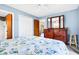 This bedroom features a comfortable bed with coastal bedding and a dresser with a tri-fold mirror at 7897 Russell Creek Dr, Edisto Island, SC 29438