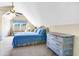 Cozy bedroom with sloped ceilings, ceiling fan, sitting area, and charming coastal decor at 7897 Russell Creek Dr, Edisto Island, SC 29438
