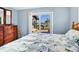 Bedroom with sliding glass doors to a deck with views, complemented by a cozy coastal-themed bed and dresser at 7897 Russell Creek Dr, Edisto Island, SC 29438