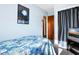 Simple bedroom with a blue and white patterned bedspread, closet, and entertainment stand at 7897 Russell Creek Dr, Edisto Island, SC 29438