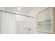 Bright and clean shower features a white shower curtain and wall art at 5577 Ruby Falls Dr, North Charleston, SC 29420