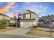 Charming two-story home boasts a two-car garage and a well-manicured front yard under a beautiful sunset sky at 9676 Godwin St, Ladson, SC 29456