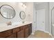 A bright bathroom features double sinks, white countertops, and dark wood cabinets at 1007 Halfacre Ln, Ladson, SC 29456