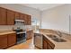 Stylish kitchen with stainless steel appliances, warm-toned cabinets, and neutral countertops and flooring at 1007 Halfacre Ln, Ladson, SC 29456
