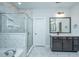 Modern bathroom featuring marble tile, glass shower, a vanity with dark wood cabinets, and stylish light fixtures at 101 Firebrick Way, Summerville, SC 29483