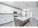 Modern kitchen with stainless appliances, white cabinets, and a large island with stone countertops at 101 Firebrick Way, Summerville, SC 29483