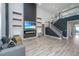 Contemporary living room with a fireplace, dark accent wall, a staircase, and stylish decor elements at 101 Firebrick Way, Summerville, SC 29483