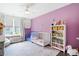 Bright bedroom with pink wall, crib, bookshelf, window and play area at 1052 Sago Palm Ct, Mount Pleasant, SC 29429