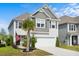 Inviting two-story home with a two-car garage, palm tree, and an American flag waving in the breeze at 1052 Sago Palm Ct, Mount Pleasant, SC 29429