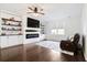 Relaxing living room features a fireplace, built-in shelves, a ceiling fan, and hardwood floors with a cozy rug at 1052 Sago Palm Ct, Mount Pleasant, SC 29429