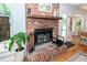 Rustic brick fireplace with a wood mantle, hardwood floors, and decorative accents at 1070 Blue Marlin Dr, Charleston, SC 29412