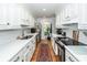 Galley kitchen with white cabinets, stainless appliances, and hardwood floors at 1070 Blue Marlin Dr, Charleston, SC 29412